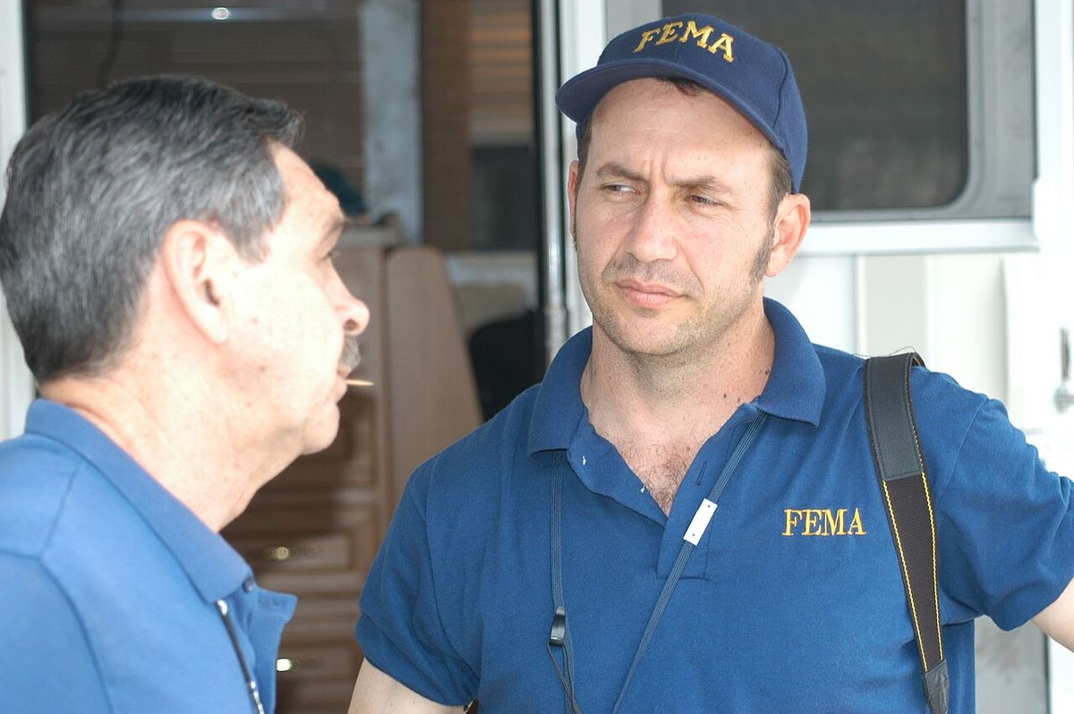Dyersburg, TN, May 18, 2003 --- FEMA photographer Mark Wolfe (right) and TEMA Area Coordinator, Danny Daniel, discuss the Mobile Disaster Re