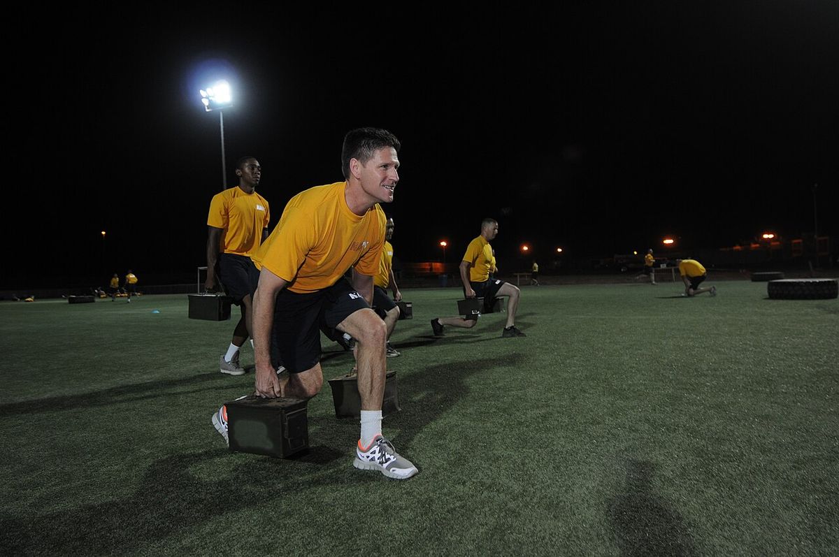 Assistant Secretary of the Navy for Manpower and Reserve Affairs Juan M. Garcia performs weighted lunges during an early morning physical tr
