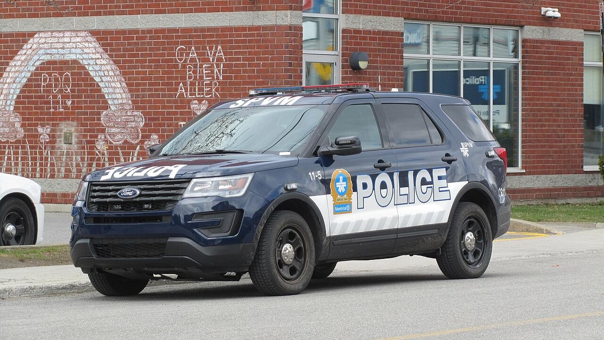 A Montreal police Ford Explorer SUV from the Service de Police de Montréal parked besides station 11 on Somerled street. Behind is a message