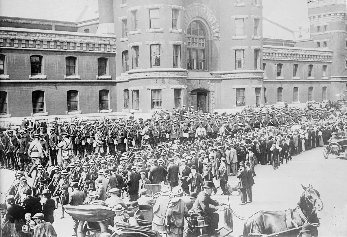 48th Highlanders, 12th Infantry, & 10th Royal leave Toronto for camp, with the Toronto Armouries in the background. From a glass negative. T