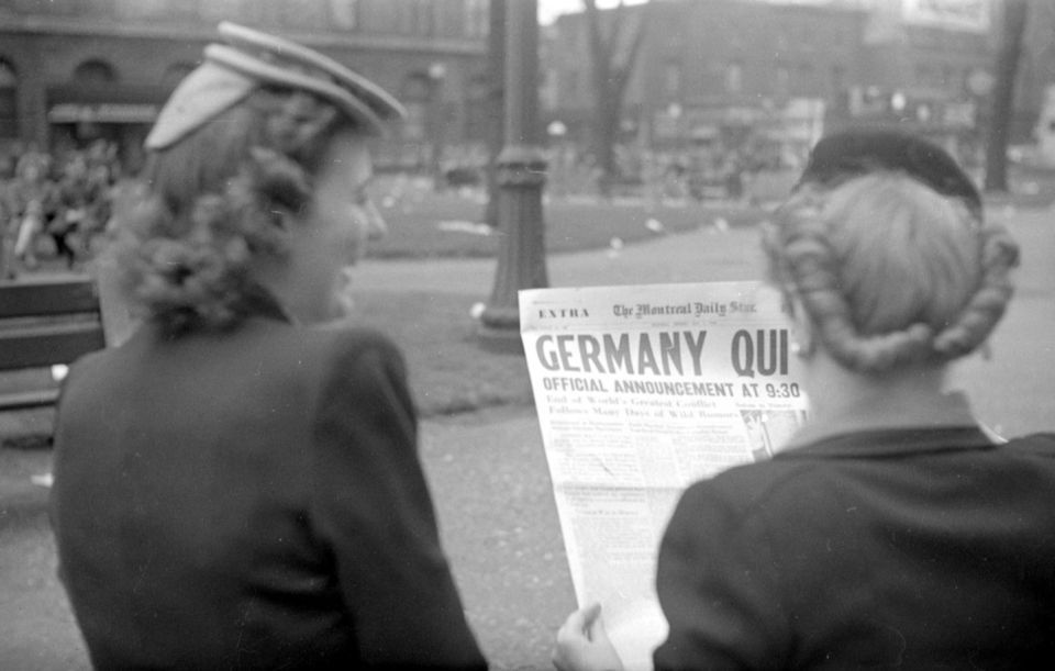 Two young women standing on Saint Catherine Street in Montreal, read the front page of The Montreal Daily Star. The title "Germany Quits" an