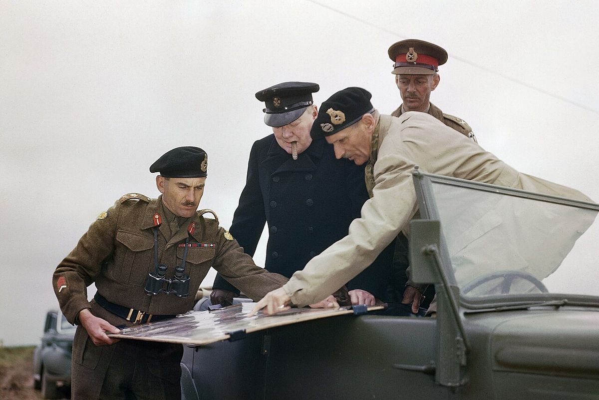 General Sir Bernard Montgomery indicating positions on a map held by the Commander of the 2nd Canadian Division, General G. G. Symonds to th