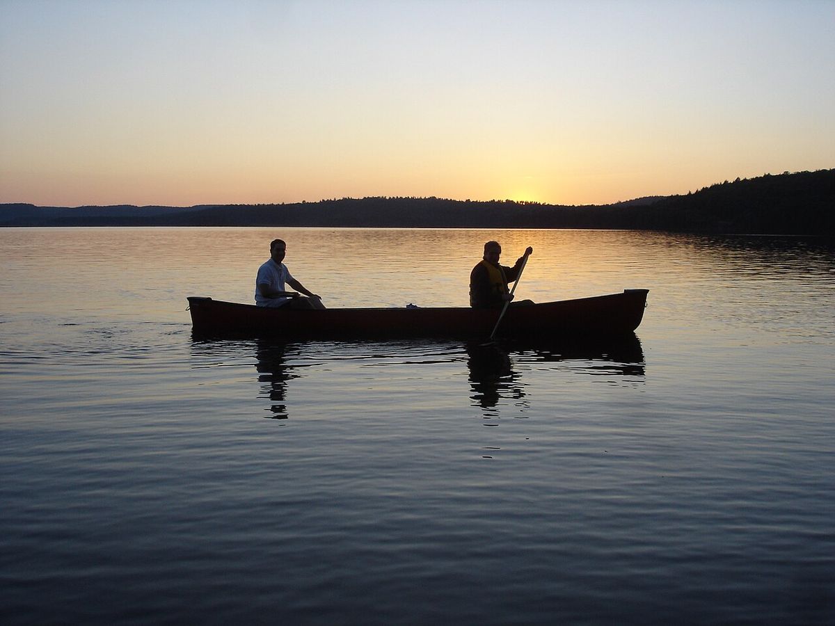 Canoeing Algonquin Park two people sunset lake Canada Ontario