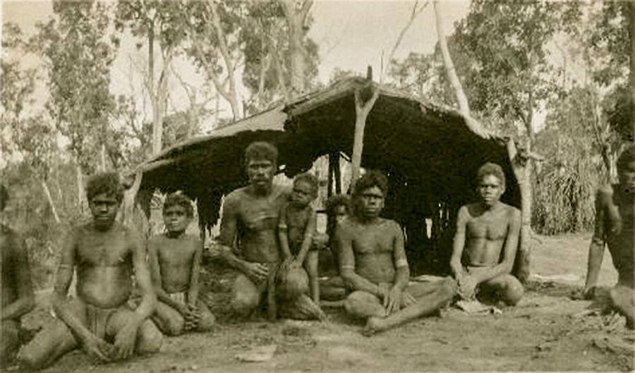 Some Aboriginal boys and men in front of a bush shelter, Groote Eylandt, Northern Territory, c. 1933