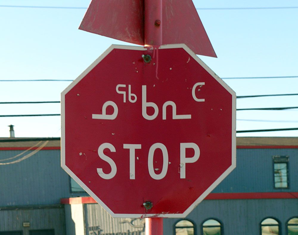 Red octagonal Stop sign with "STOP" in Inuktitut: ᓄᕐᒃᑲᕆᑦ, in Iqaluit, Nunavut.