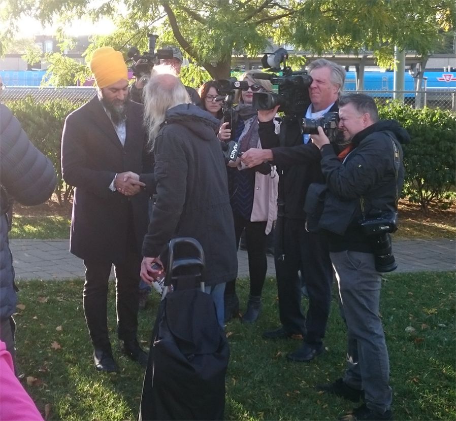 Leader of the New Democratic Party Jagmeet Singh shakes a man's hand during a morning campaign stop at the parkette on the north side of the